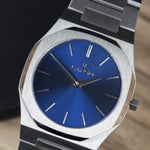 Reloj plateado con 2 manecillas y dial azul