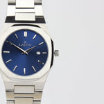 Reloj plateado con 2 manecillas y dial azul con fecha