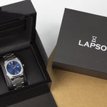 Reloj plateado con 2 manecillas y dial azul con fecha